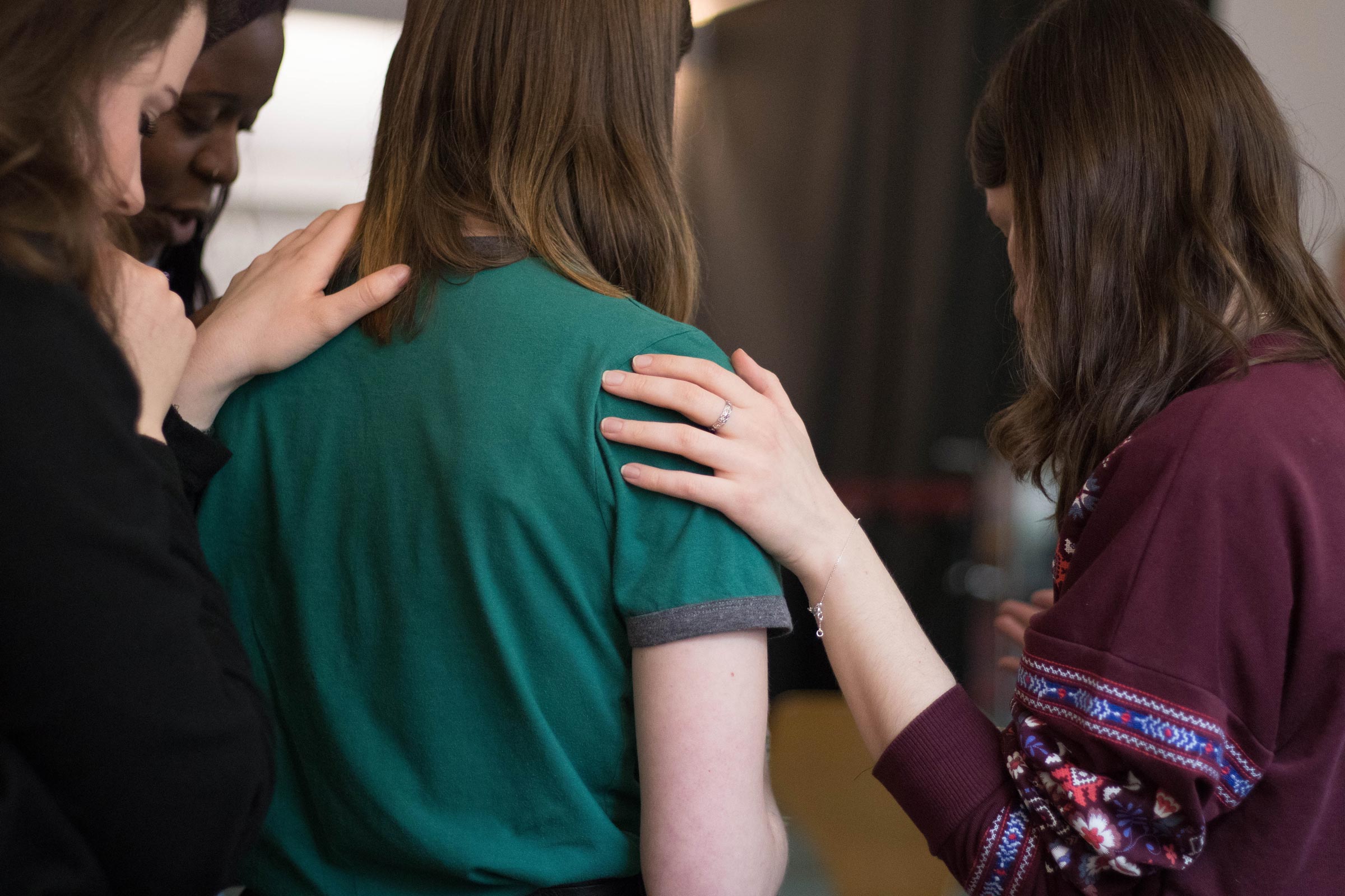 Photo of two people with gentle hands soothing a sad person